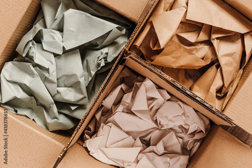 Cardboard boxes with crumpled paper inside for packaging goods from online stores, eco friendly packaging made of recyclable raw materials - obrazy, fototapety, plakaty 