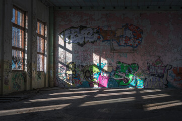 Abandoned Soviet time swimming pool and sports hall complex. Colorful graffiti paintings on the walls. Urban exploration.