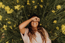 Young Woman Lying In Yellow Wildflower Field, Overhead Portrait, Jalama, California, USA