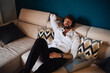 © Connect Images - Mid adult man reclining on sofa listening to headphones with eyes closed
