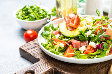 Wall Mural - Green salad with avocado, salad leaves, jamon serrano and tomatoes. Healthy diet lunch.