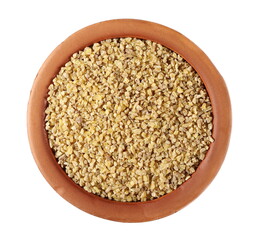 Dry bulgur pile in clay pot isolated on white background, top view