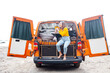 Woman on vacation with her orange van on the beach