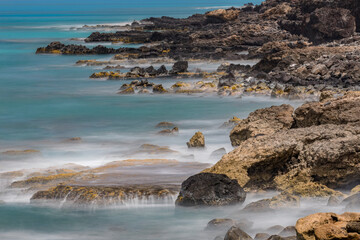 Sticker - Long exposure on surf along rocky beach, Maui, Hawaii.