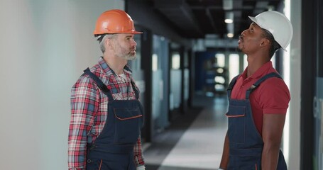 Wall Mural - Electrical workers. Cooperative team of caucasian and african technician workers talking about lighting repair system operate together. Communication.