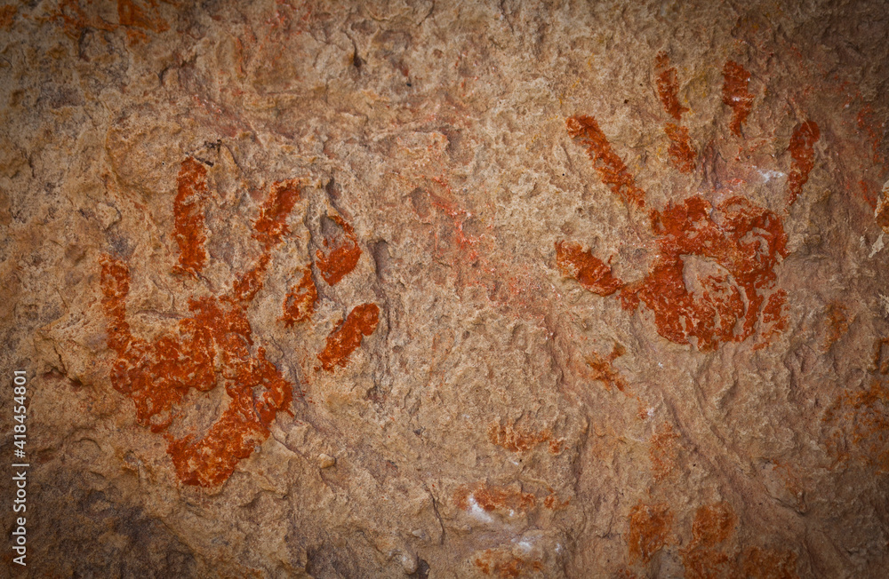 A pair of ochre hands, Red, Orange, Yellow handprints on a rock, Aboriginal art in Queensland, Australia.