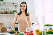 © My Ocean studio - Cute happy young brunette woman in good mood preparing a fresh vegan salad for a healthy life in the kitchen of her home