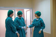© SizeSquare's - A surgeon in a surgical gown Shaking hands together demonstrating a successful partnership that has completed surgery within the clinic hospital..