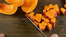 A Man Moves Aside A Sliced Pumpkin With A Knife. Pumpkin Lies On A Wooden Cutting Board. Point Of View. Slow Motion Video. Home Cooking Theme.