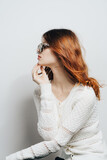 Fototapeta Konie - Woman in a white sweater with sunglasses studio fashion lifestyle glamor