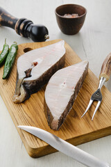 Wall Mural - Closeup view of raw fresh halibut steak on wooden cutting board