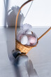 Jajka wielkanocne pastelowe w koszyku w otoczeniu piór , święta wielkanocne