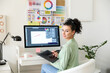 © Pixel-Shot - Young female designer working in office