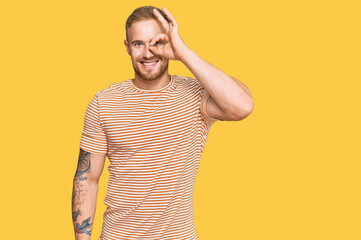 Wall Mural - Young irish man wearing casual clothes smiling happy doing ok sign with hand on eye looking through fingers