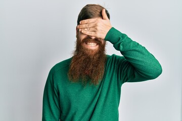 Sticker - Redhead man with long beard wearing casual clothes smiling and laughing with hand on face covering eyes for surprise. blind concept.