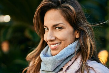 Young hispanic woman smiling happy standing at the city.