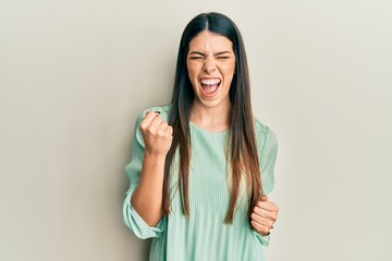 Young hispanic woman wearing casual clothes celebrating surprised and amazed for success with arms raised and eyes closed