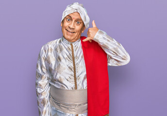 Poster - senior hispanic man wearing tradition sherwani saree clothes smiling doing phone gesture with hand a