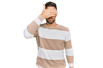 Wall Mural - Handsome man with beard wearing casual clothes and glasses covering eyes with hand, looking serious and sad. sightless, hiding and rejection concept