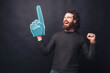 © Vulp - Photo of amazed bearded man in casual celebrating victory and pointing with fan glove