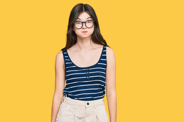 Wall Mural - Young beautiful caucasian girl wearing casual clothes and glasses puffing cheeks with funny face. mouth inflated with air, crazy expression.