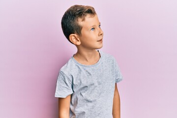 Wall Mural - Adorable caucasian kid wearing casual clothes looking to side, relax profile pose with natural face and confident smile.