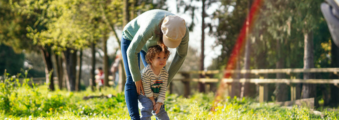 Two-year-old boy angry in a park in spring near his mother. kids tantrum concept. life style