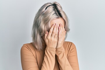 Wall Mural - Young blonde girl wearing casual clothes with sad expression covering face with hands while crying. depression concept.