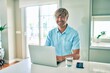 © Krakenimages.com - Young irish man smiling happy working using laptop sitting on the table at home.