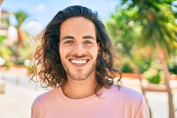 Wall Mural - Young hispanic man smiling happy looking to the camera at city.