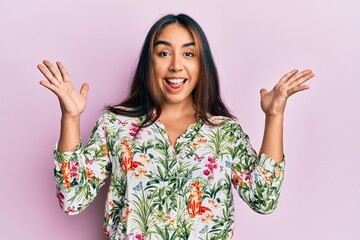 Young latin woman wearing casual clothes celebrating victory with happy smile and winner expression with raised hands