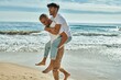 Lovely gay couple on piggyback ride at the beach.