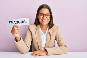 Canvas Print - Beautiful hispanic business woman holding financial message paper looking positive and happy standing and smiling with a confident smile showing teeth