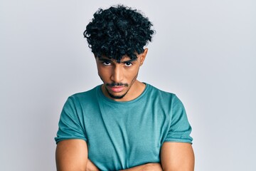 Wall Mural - Young arab handsome man wearing casual clothes skeptic and nervous, disapproving expression on face with crossed arms. negative person.