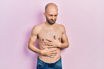 Sticker - Young bald man standing shirtless with hand on stomach because indigestion, painful illness feeling unwell. ache concept.