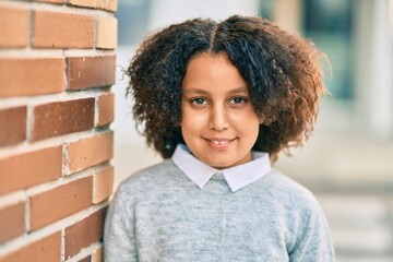 Sticker - Adorable hispanic student child girl smiling happy standing at the city.