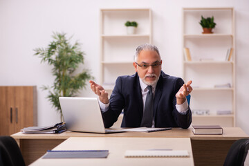 Old male employer sitting in the office