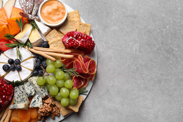 Wall Mural - Assorted appetizers served on light grey table, top view. Space for text