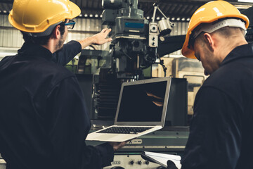 Skillful factory worker working with laptop computer to do procedure checklist . Factory production line operator occupation quality control concept .