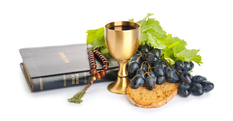 Holy Bible with bread, beads and chalice of wine on white background