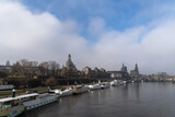 Fototapeta Londyn - A classical view of the Dresden city with white clouds and blue skies. Slight blurry appearance due to light fog in the background