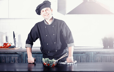 Man cook preparing food at the kitchen of vegetables