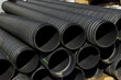 Plastic PVC pipes stacked main black pipes on heap of polyethylene pipes for a drain supply system for laying of city communications