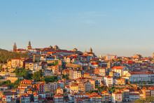 Porto, Portugal Old City Skyline Or Downtown With Colorful Buildings And Orange Rooftops On Sunset
