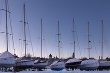 Row Of Sailboats Docked At The Louise Basin Marina Seen During An Early Winter Morning, With Old Town Buildings In The Background, Quebec City, Quebec, Canada