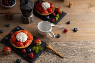 Poster - Homemade dessert strawberry pie with raspberry's and blue berry's and a coffee.Top view. Homemade organic strawberry pie with raspberry and blue berry with a coffee on a wooden table.Top view.