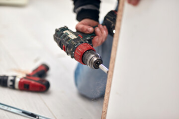 Wall Mural - Handyman worker assembling furniture and fixing it.