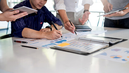 Business people meeting to find analytical ideas pointing to the graph at the office.