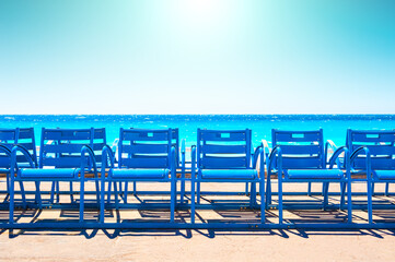 Wall Mural - Famous blue chairs on the Promenade des Anglais in Nice, France. Beautiful turquoise sea and the blue sky. Travel destination concept