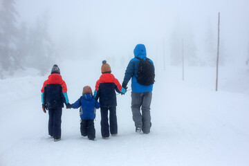 Canvas Print - Sweet children, playing in the snowAdorable family with three children, having family time, walking together in deep snow in the mountains